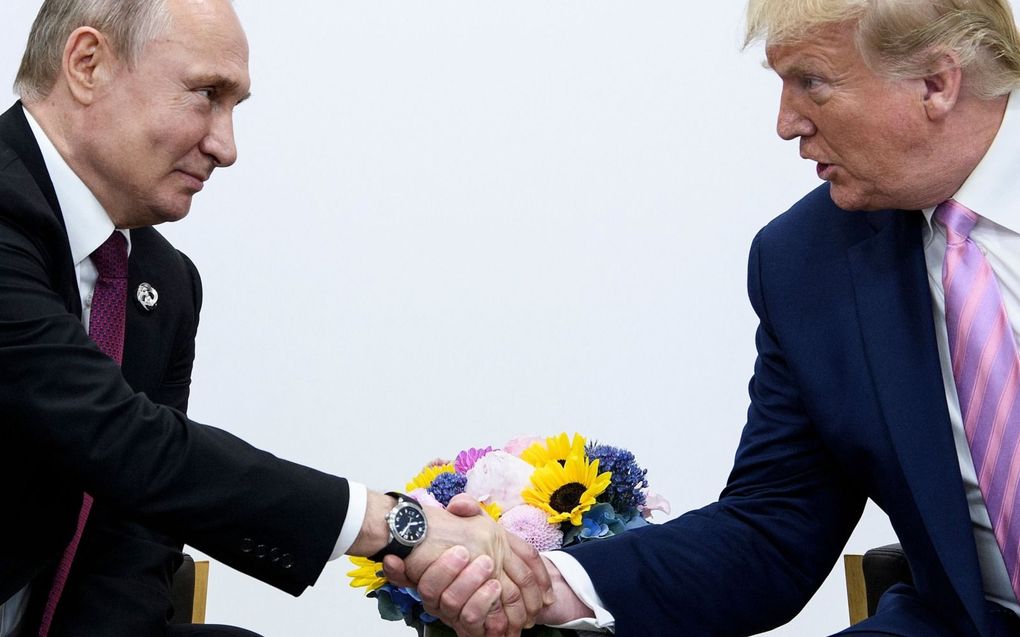 De Russische president Vladimir Poetin (l.) in juni 2019 met de toenmalige Amerikaanse president Donald Trump. beeld AFP, Brendan Smialowski