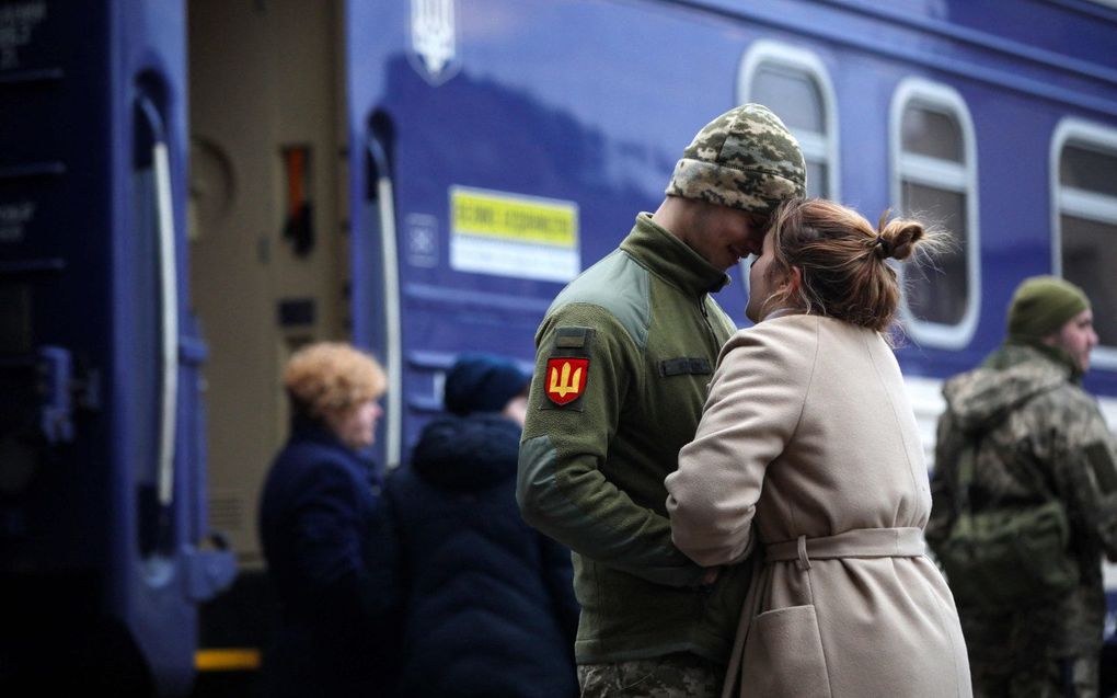 Een Oekraïense militair neemt op het centraal station van Kiev afscheid van zijn vriendin. beeld AFP, Aleksey Filippov