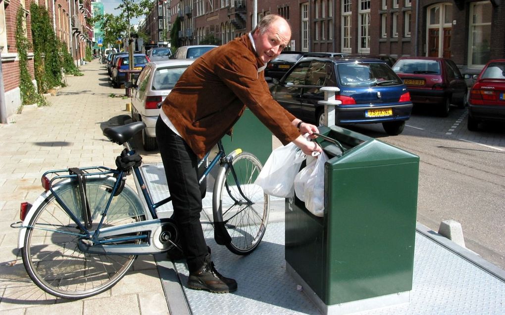 Een fietser deponeert huisafval in een ondergrondse container. EVB is voorstander van dergelijke afvalcontainers, die kliko’s aan huis kunnen vervangen. beeld ANP, Cor Mulder