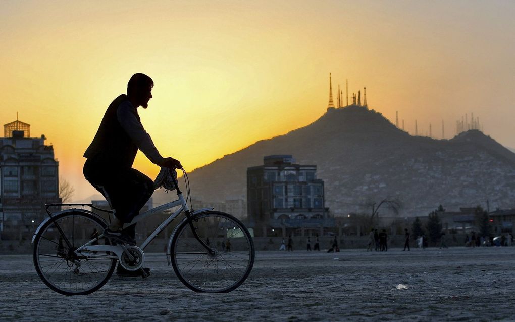 Een man rijdt op zijn fiets in het Chaman-e-Hozori-gebied in Kabul, Afghanistan. beeld AFP, Sahel Arman