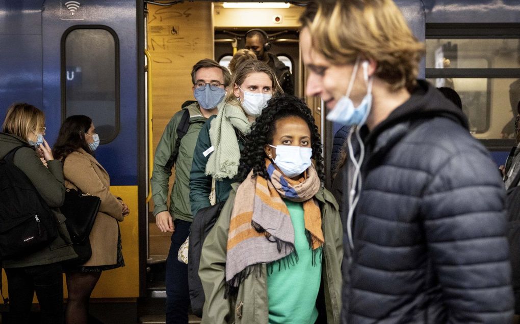 Forenzen op het perron op Utrecht Centraal. In het openbaar vervoer zijn mondkapjes niet langer verplicht. beeld ANP RAMON VAN FLYMEN