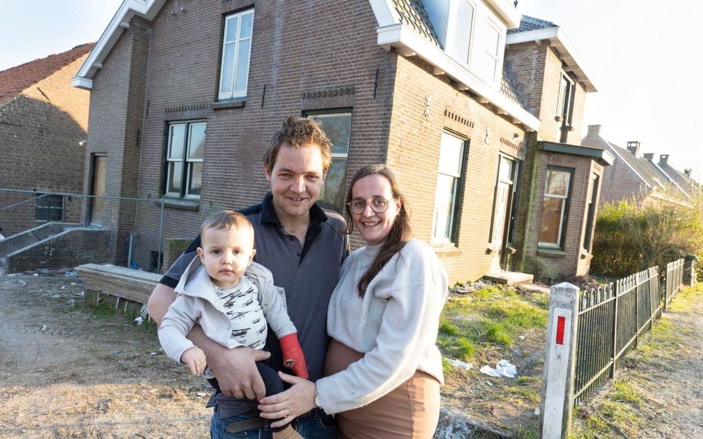 Reyer en Christine met hun 1-jarige zoontje Ezra, voor hun klushuis in Gellicum. beeld Anton Dommerholt