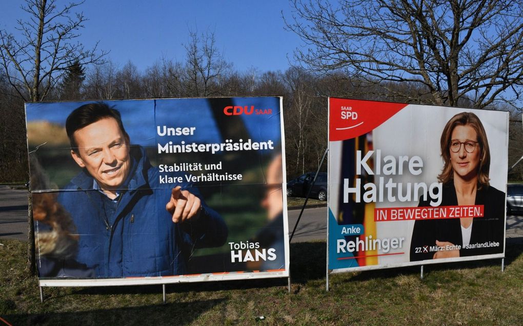 In de Duitse deelstaat Saarland worden zondag verkiezingen gehouden. Links een verkiezingsaffiche met Tobias Hans van de christendemocraten, rechts een poster met Anke Rehlinger van de sociaaldemocraten. Beeld ANP, Becker Bredel