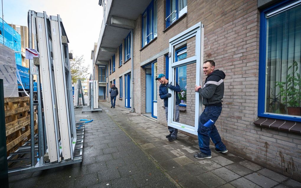 Een kozijn met dubbelglas wordt in een sociale huurwoning van de Haagse woningcorporatie Staedion gehangen tijdens verduurzamende renovatie werkzaamheden in de wijk Transvaal. beeld ANP, Phil Nijhuis