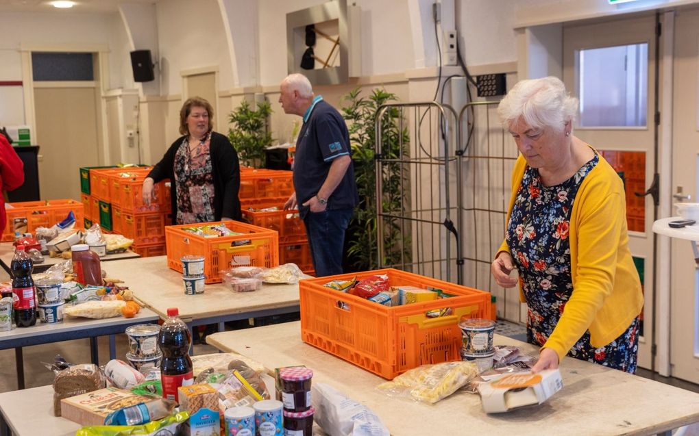 In de Maranathakerk, een van de uitdeelpunten van voedselbank in de regio Rotterdam, maken vrijwilligers voedselpakketten in gereedheid.  Vrijwilliger Marlies Vriesema (r.) houdt er rekening mee dat minderbedeelden de komende tijd vaker een beroep doen op de voedselbank.  beeld Roel Dijkstra