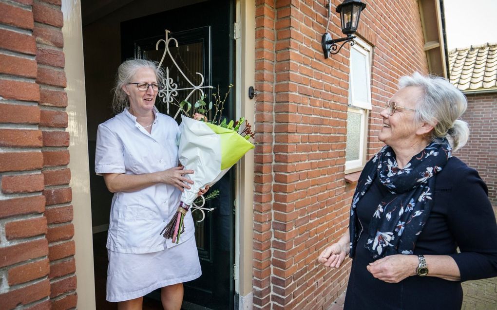 Corrie Oomen (r.) overhandigt predikantsvrouw Gerda van Meggelen (l.) een bloemetje. Oomen: „Ze ziet de nood bij mensen. Ze helpt haar naaste belangeloos. Ik heb veel respect voor haar.” beeld Maikel Samuels