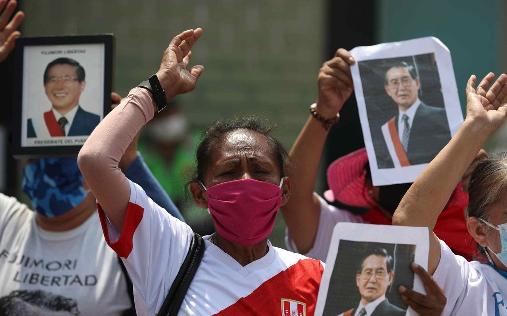 Aanhangers van de Peruaanse president Alberto Fujimori demonstreren buiten bij de plaats waar hij wordt vastgehouden in Lima, Peru. beeld EPA, Paolo Aguilar