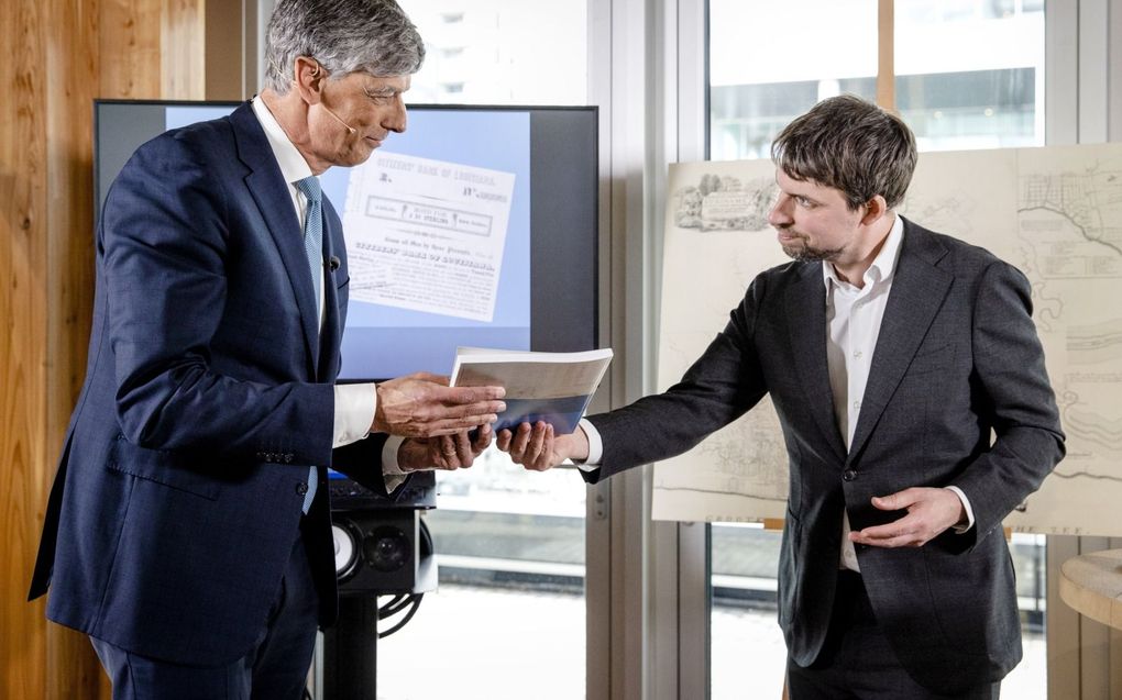 ABN AMRO-topman Robert Swaak ontvangt uit handen van hoofdonderzoeker Pepijn Brandon (rechts) het onderzoek naar de rol van de voorgangers van de bank in de slavernij. beeld ANP, Sem van der Wal