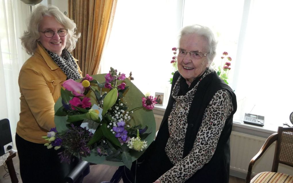 Ina Goud-Koster (r.) geeft een bloemetje aan haar dochter Caroline Hamelink-Goud omdat ze dag en nacht voor haar klaarstaat. beeld Camile Schelstraete