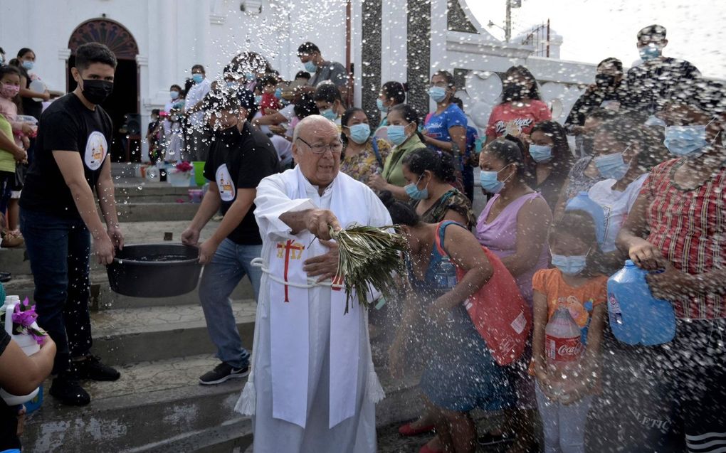 Een rooms-katholieke priester in El Salvador zegent omstanders. beeld AFP, Marvin Recinos