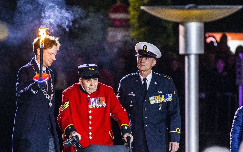 De burgemeester van Wageningen, Floor Vermeulen arriveert samen met de 96 jarige Britse WO2 veteraan Harry Rawlings met het bevrijdingsvuur tijdens de bevrijdingsvuurceremonie bij Hotel De Wereld. De ceremonie staat symbool voor de overgang van het herdenken van oorlogsslachtoffers naar het vieren van de vrijheid. beeld ANP, Vincent Jannink