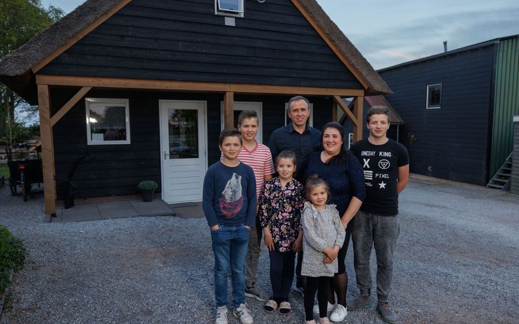 Oleksandr en Vita Litvinchuk en hun gezin, voor hun tijdelijk huisje op het erf van de families Vahl in IJsselmuiden.  beeld Freddy Schinkel