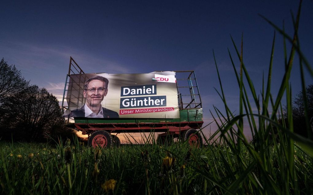 De Duitse deelstaat Sleeswijk-Holstein gaat zondag naar de stembus. Foto: een verkiezingsaffiche van de CDU met lijsttrekker Daniel Günther. beeld AFP, Axel Heimken