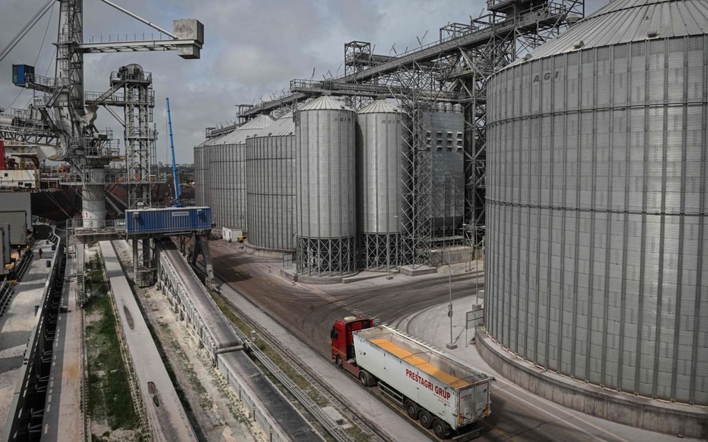 Een vrachtwagen die maïs vervoert, passeert grote graansilo’s in de Roemeense haven van Constanta. De haven wil een exportknooppunt worden voor buurland Oekraïne. beeld AFP, Daniel Mihailescu