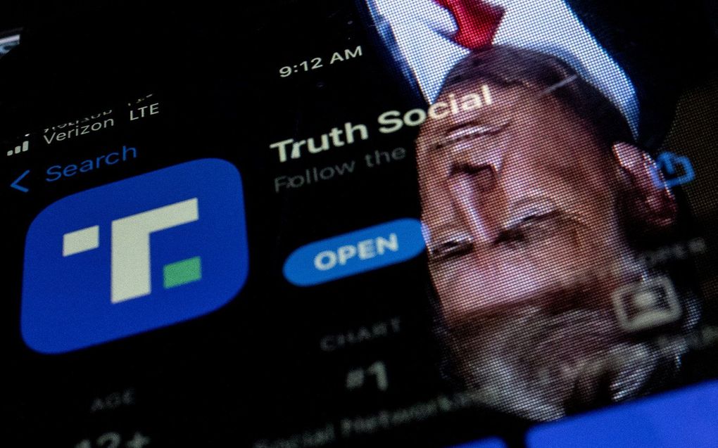 De voormalig president Donald Trump is weerspiegeld in een telefoonscherm waarop de Truth Social-app wordt weergegeven. De nieuwe app voor sociale media van Donald Trump begon eind 21 februari met een geleidelijke uitrol en zou eind maart "volledig operationeel" zijn. Trump heeft Truth Social beschreven als een alternatief voor Facebook, Twitter en YouTube, die hem allemaal verboden hebben. beeld AFP, Stefani Reynolds