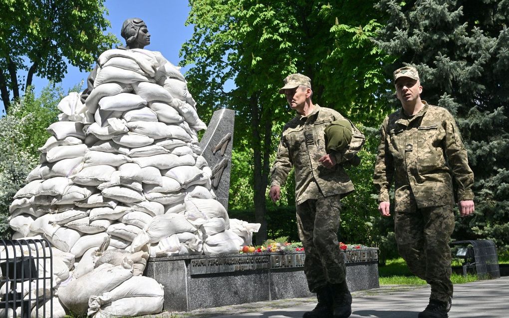 Oekraïense militairen lopen langs het met zandzakken bedekte monument voor WO II-held Air Marshal van het Sovjetleger Ivan Kozhedub - de hoogst scorende Sovjet- en geallieerde gevechtspiloot - in Kiev. beeld AFP, Sergei Supinsky
