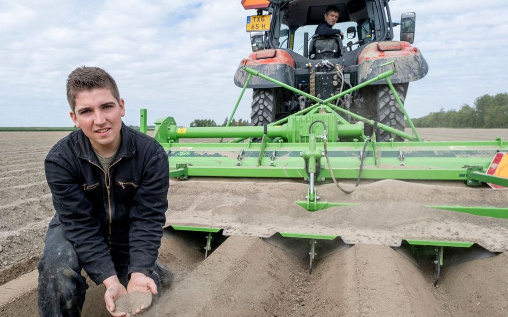 Geert van de Velde uit Dreischor haalt zijn hand door de stofdroge grond, terwijl zijn vader Jan Willem op de trekker zit. beeld Dirk-Jan Gjeltema