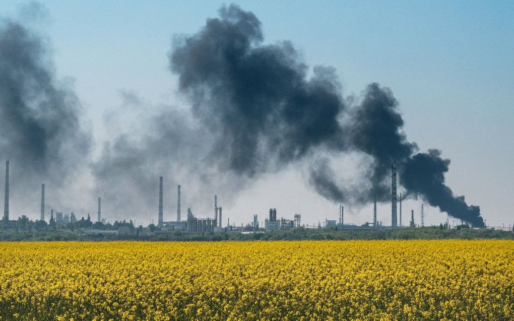 Opstijgende rook na een Russische artillerieaanval op een olieraffinaderij in de buurt van Lysychansk, 9 mei 2022. beeld AFP, Yasuyoshi Chiba