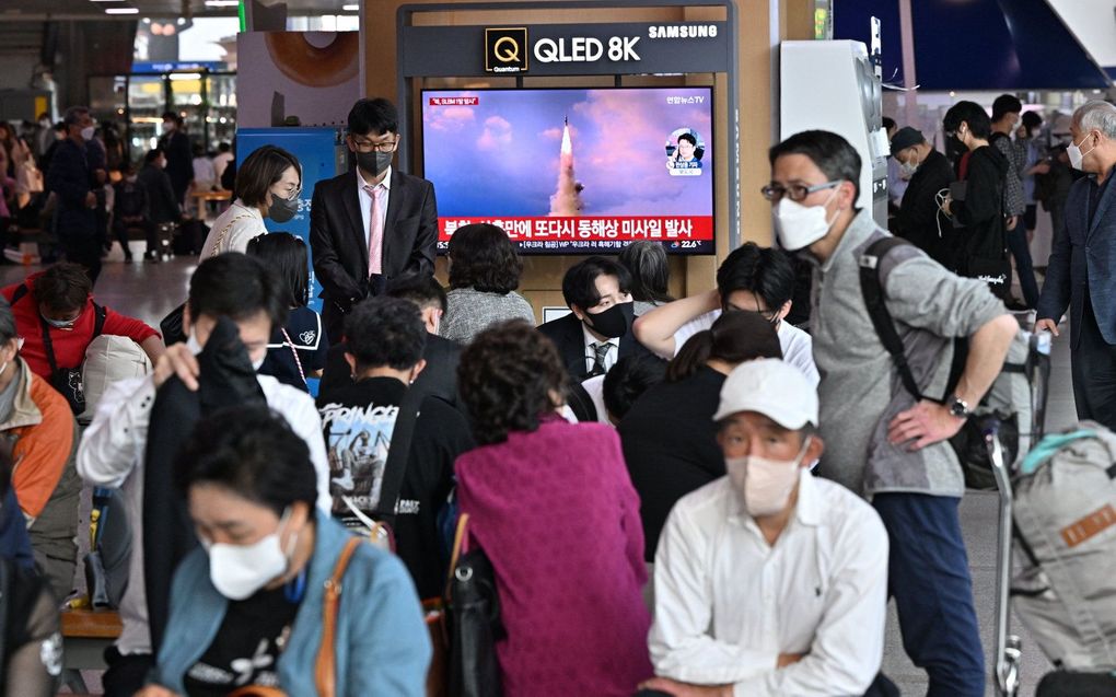 Mensen kijken naar een televisiescherm met beelden van een Noord-Koreaanse rakettest, op een treinstation in Seoel. beeld AFP, Jung Yeon-je