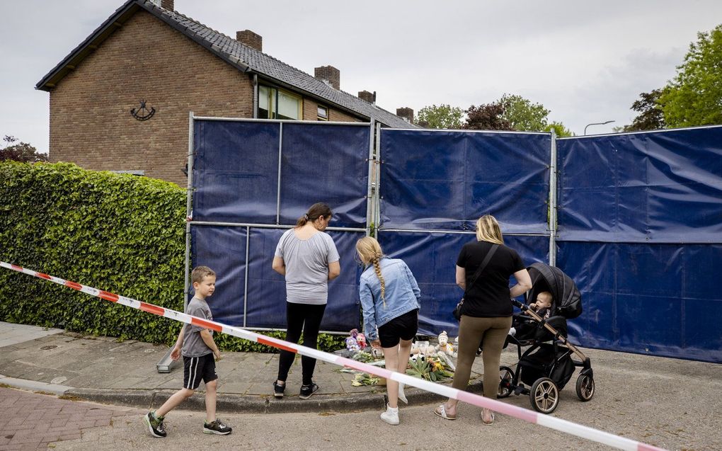 Omstanders bij een monumentje van bloemen en knuffels bij de woning in Geldermalsen. beeld ANP, SEM VAN DER WAL