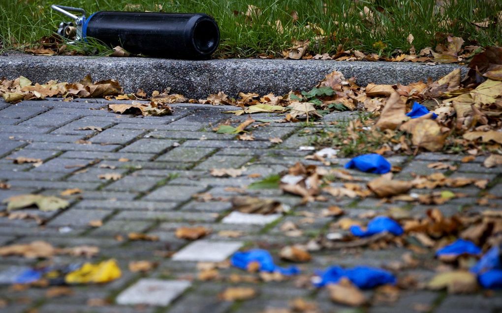 Een lege gasfles, waarin lachgas gezeten heeft, om ballonnen mee te vullen op een parkeerplaats in een woonwijk. beeld ANP, Robin van Lonkhuijsen