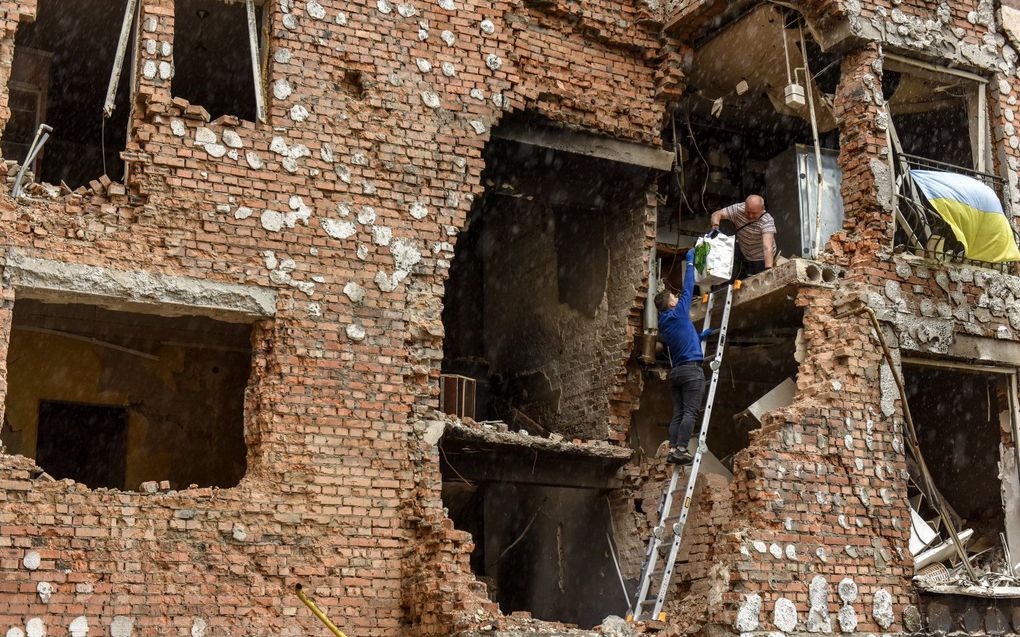 Mensen zijn teruggekeerd naar hun kapotgeschoten appartement in Kiev om waardevolle eigendommen op te halen. beeld EPA, OLEG PETRASYUK