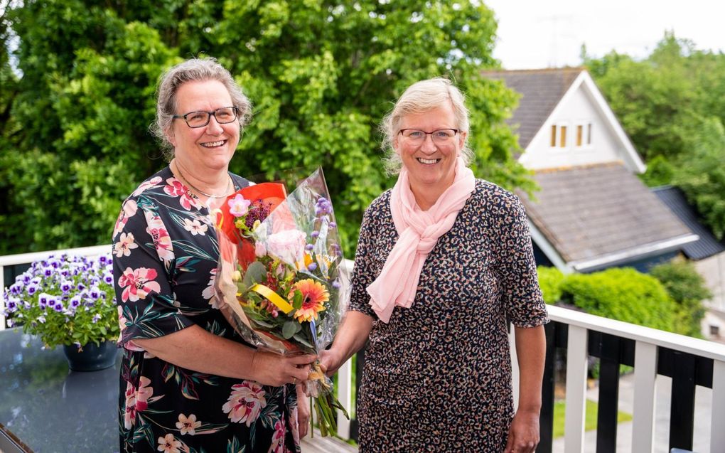 Nelly De Groot-Molenaar (l.) geeft haar zus Tineke Meerkerk-Molenaar (r.) een bloemetje. „Ik bewonder haar dienstbaarheid, je doet nooit tevergeefs een beroep op haar.” beeld Cees van der Wal