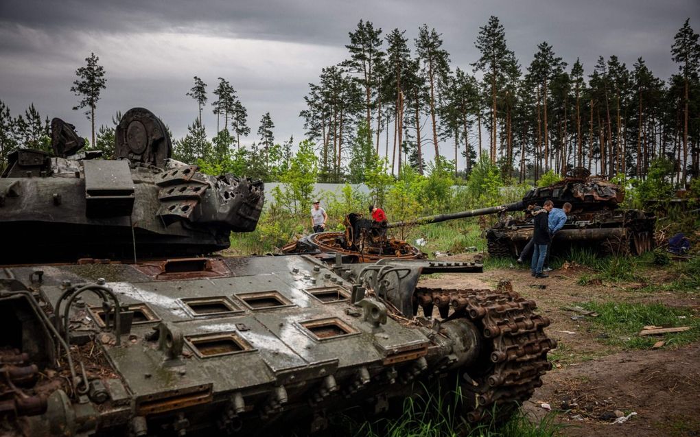 Oekraïners inspecteren een vernietigde Russische tank buiten de hoofdstad Kiev. In en rond de Oekraïense hoofdstad is het op dit moment betrekkelijk rustig. Zware strijd wordt in het zuidoosten van Oekraïne gevoerd. beeld AFP, Dimitar Dilkoff