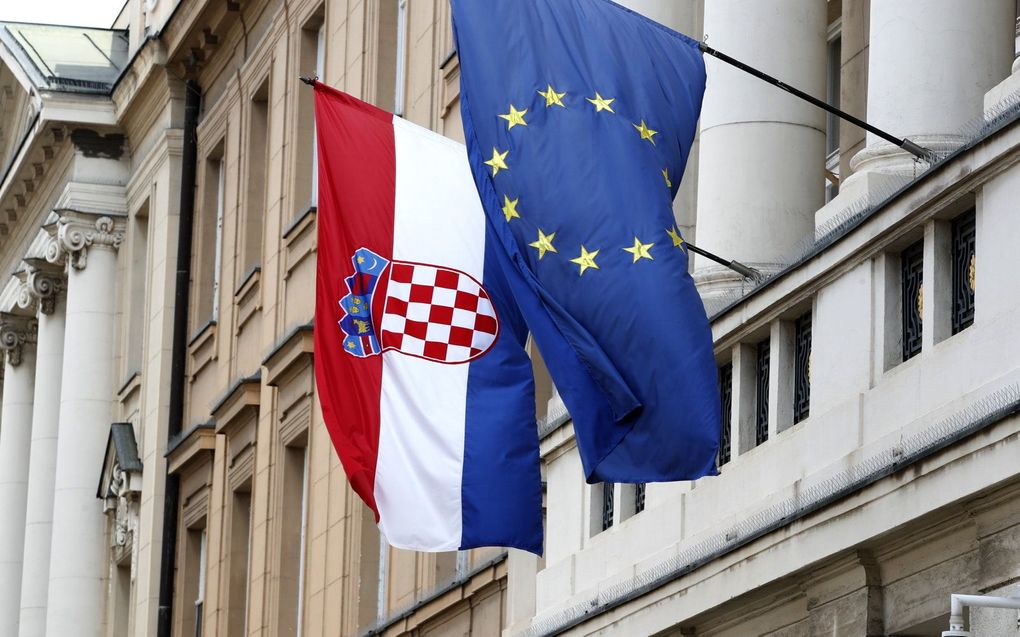 De vlaggen van Kroatië (l.) en de Europese Unie aan het parlementsgebouw in Zagreb, Kroatië. beeld EPA, ANTONIO BAT