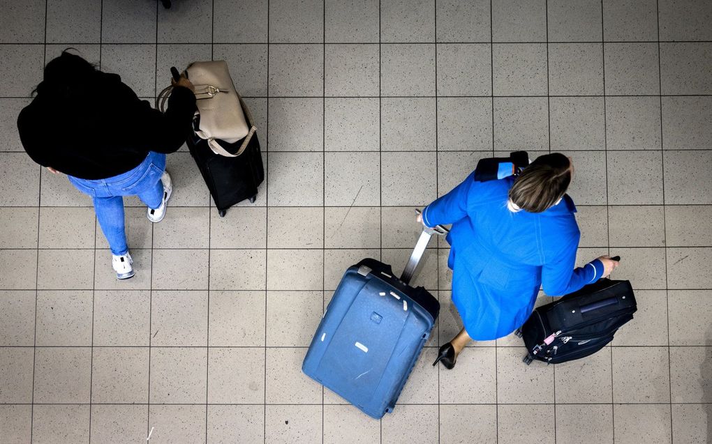 Een stewardes van KLM loopt over de luchthaven Schiphol. beeld ANP, RAMON VAN FLYMEN