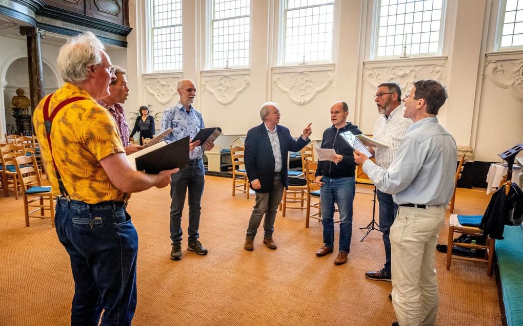 Het falsetkoor repeteert in Delft onder leiding van David Hurley (m.). beeld Roel Dijkstra Fotografie