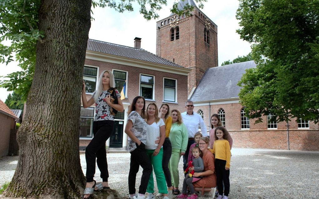 Jan Meerkerk en dochter Caroline Meerkerk (gehurkt rechts voor) te midden van Oekraïense vluchtelingen die worden opgevangen in de pastorie van de hervormde gemeente in Schoonrewoerd. beeld William Hoogteyling