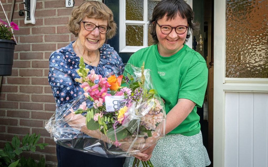 Madelien van Wageningen geeft een bloemetje aan Ans van Alphen. beeld Wim van Vossen