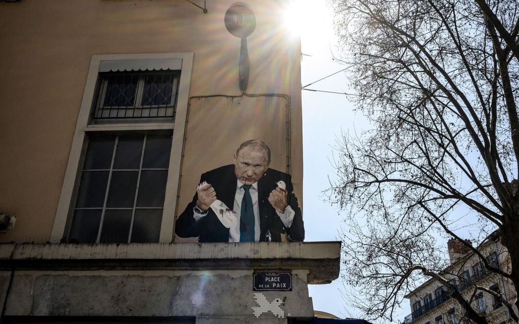 Schildering van de Russische president Poetin die een vredesduif de nek omdraait, op de Place de la Paix in Lyon. beeld AFP, Jeff Pachoud