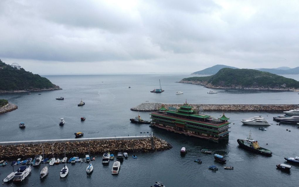 Een sleepboot trekt de Hong Kong’s Jumbo Floating Restaurant uit de haven van Aberdeen. Het drijvende restaurant was een iconische maar verouderde toeristische attractie dat er uitzag als een Chinees keizerlijk paleis. Plannen om het gevaarte te renoveren zijn op niets uitgelopen waardoor het restaurant nu weggesleept is om gesloopt te worden. beeld AFP, Yan Zhao