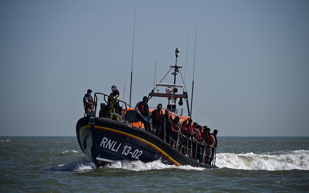Migranten die op zee zijn opgepikt bij een poging het Kanaal over te steken, worden aan land geholpen door een reddingsboot van de Royal National Lifeboat Institution (RNLI) in Dungeness aan de zuidoostkust van Engeland. beeld AFP, Ben Stansall