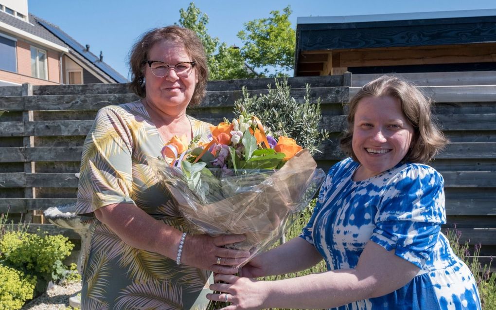 Els van der Meulen-Staal (l.) overhandigt haar dochter Nadie van der Meulen (r.) een bos bloemen, omdat die zo trouw voor haar zorgt. beeld Dirk-Jan Gjeltema