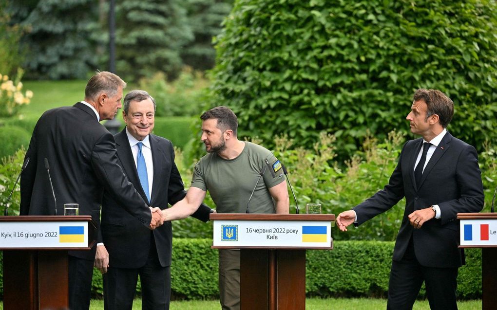 De Oekraïense president Zelenski en de Roemeense president Klaus Iohannis schudden elkaar de hand terwijl de premier van Italië Mario Draghi (2e van links) en de Franse president Emmanuel Macron (r.) toekijken tijdens een persconferentie na hun ontmoeting in het Mariinsky Paleis, in Kiev, op 16 juni. beeld AFP, Sergei SUPINSKY