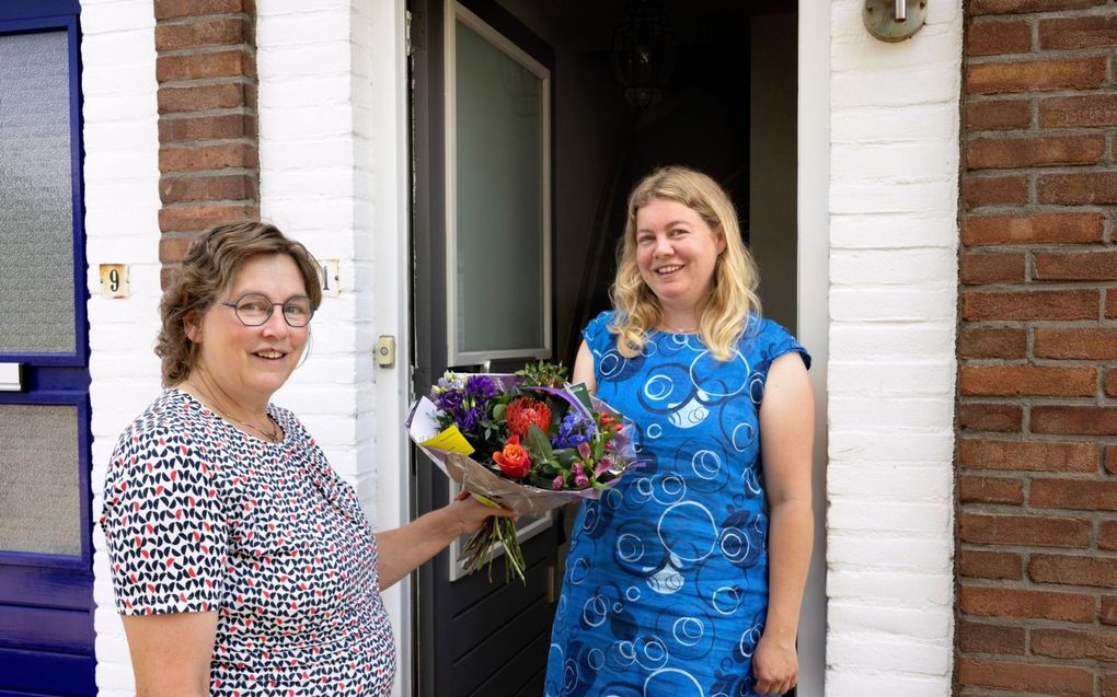 Magda van den Dool-het Lam (l.) uit Meerkerk geeft haar dochter Sara van den Dool (r.) een prachtige bos bloemen. „Ik vind het bijzonder dat ze altijd voor mij klaar staat.” beeld Dirk Hol