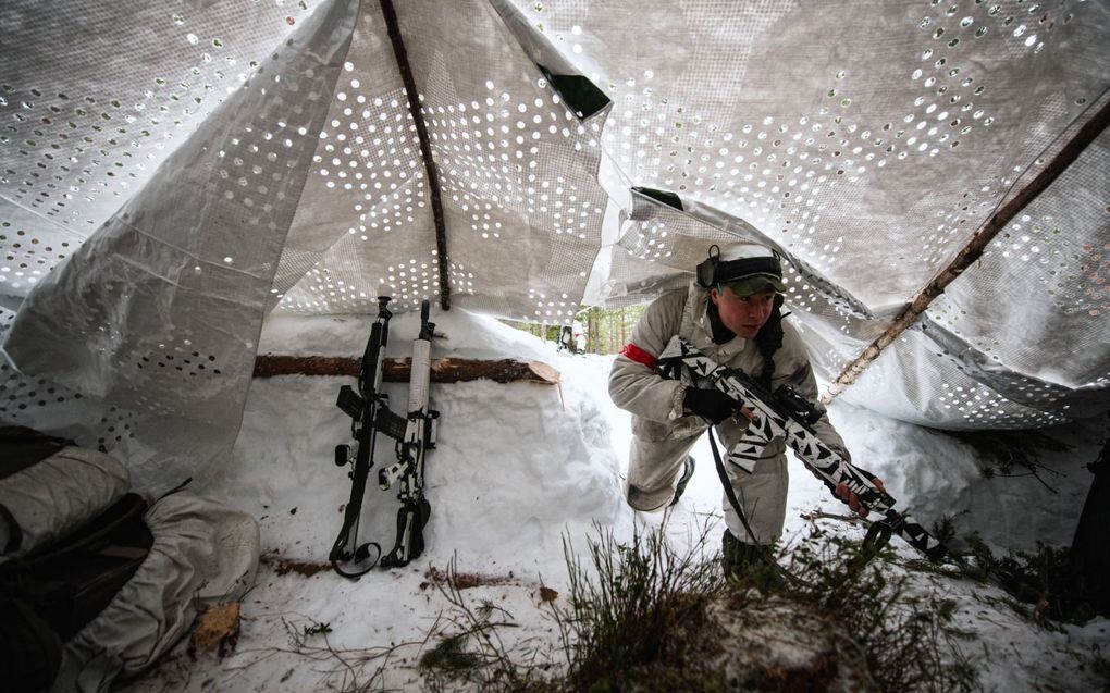 Een militair van het Zweedse Ranger Bataljon komt terug van patrouille in de bossen bij de stad Boden in noord-Zweden. De NAVO buigt zich vanaf dinsdag over toetreding van Zweden en Finland. beeld AFP, Jonathan Nackstrand