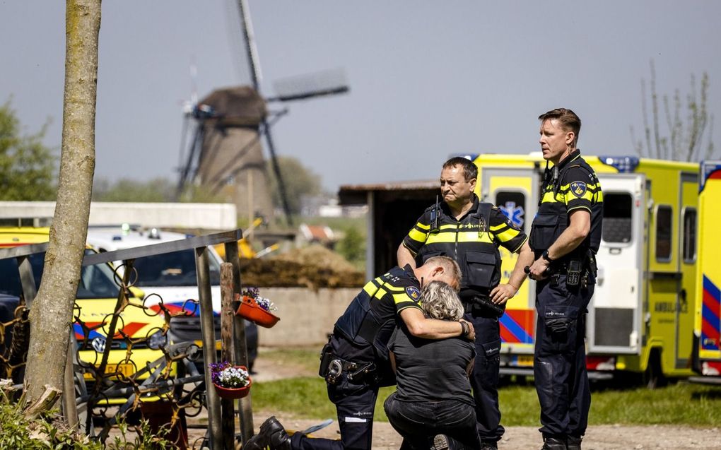 Kort na de schietpartij begin mei op zorgboerderij Tri Tardi in Alblasserdam troost een agent een vrouw. Vrijdag staat verdachte John S. voor het eerst terecht.  beeld ANP, Sem van der Wal