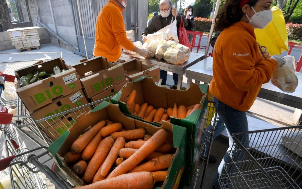 Vrijwilligers van een hulporganisatie delen voedselpakketten uit in het centrum van Milaan. Veel primaire levensbehoeften in Italië zijn een stuk duurder geworden. beeld EPA, Daniel Dal Zennaro