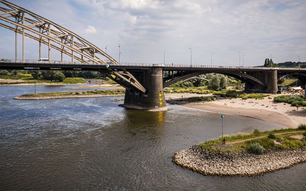 Een dronefoto van de Waalbrug bij Nijmegen. Vanwege de aanhoudende droogte dreigt het scheepvaartverkeer hinder te ondervinden door de lage waterstand in de grote rivieren. beeld ANP, ROB ENGELAAR