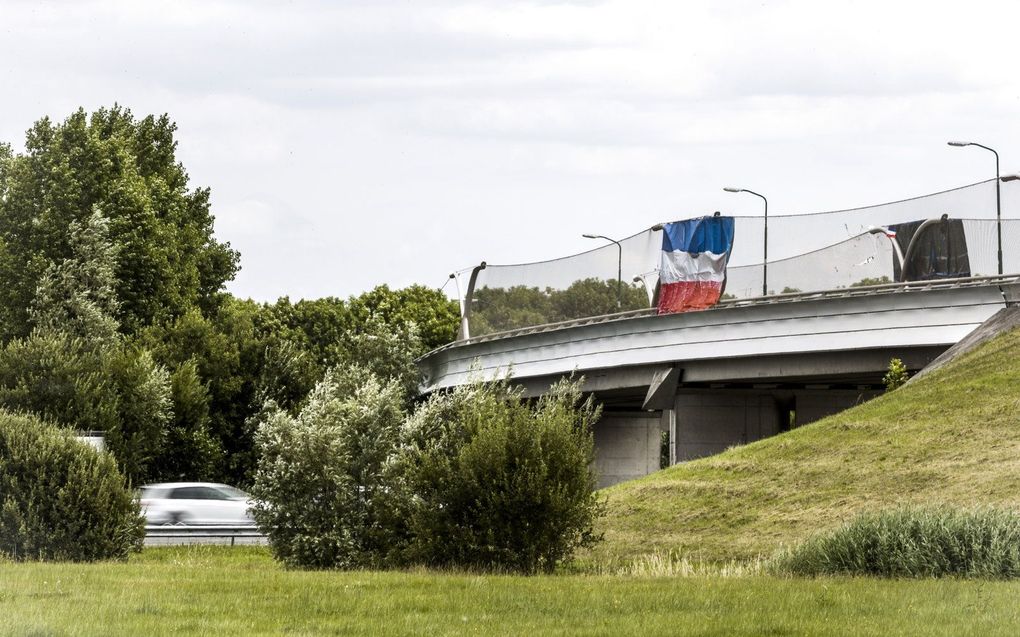 Een omgekeerde Nederlandse vlag aan een viaduct boven de A2 bij Breukelen. beeld ANP, REMKO DE WAAL