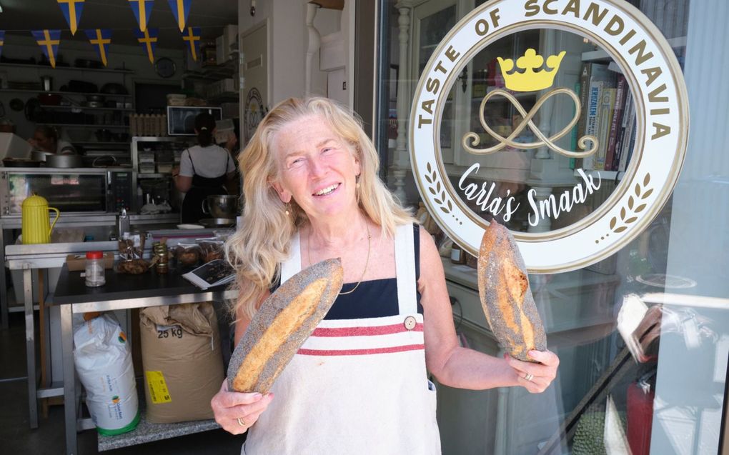 Carla Visch poseert met typisch Zweedse broden bij de ingang van haar winkel in Scheveningen. beeld Sjaak Verboom