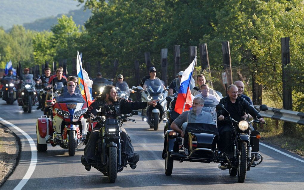 De Russische president Vladimir Poetin (r.) rijdt samen met de leider van de Nachtwolven, Aleksander Zaldostanov (l.) richting Sebastopol op de Krim, 10 augustus 2019. beeld EPA, ALEXEI DRUZHININ