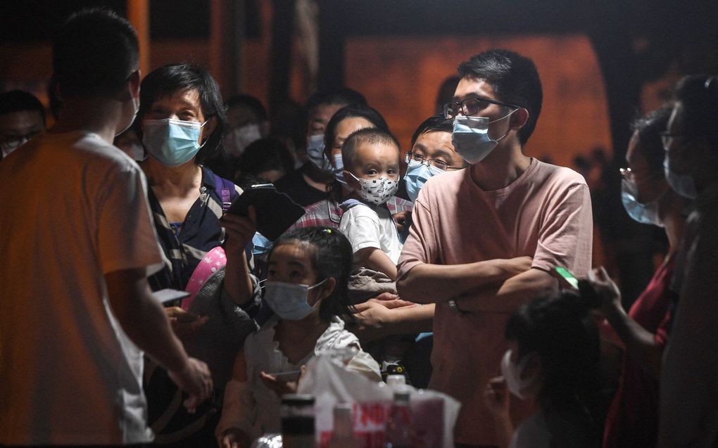 Deze foto genomen in april toont inwoners in de rij om nucleïnezuurtests te ondergaan voor het Covid-19 coronavirus in Wuhan, in China's centrale provincie Hubei. beeld AFP, STR