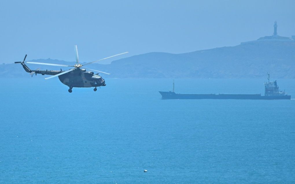 Een Chinese militaire helicopter vliegt vlak langs de grens met Taiwan. beeld AFP, Hector Retamal