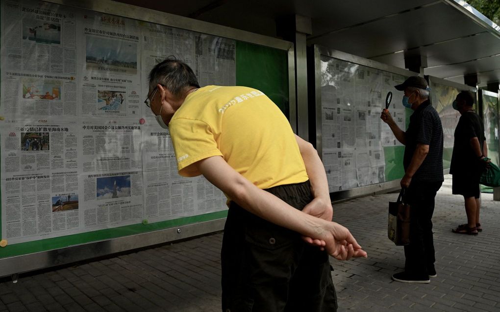 In Peking lezen mensen het nieuws over de militaire oefeningen. beeld AFP, Noel Celis