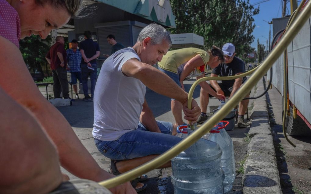 Inwoners van Mykolajiv halen water halen bij tappunten. Water uit de kraan is ondrinkbaar. beeld AFP, Bulent Kilic